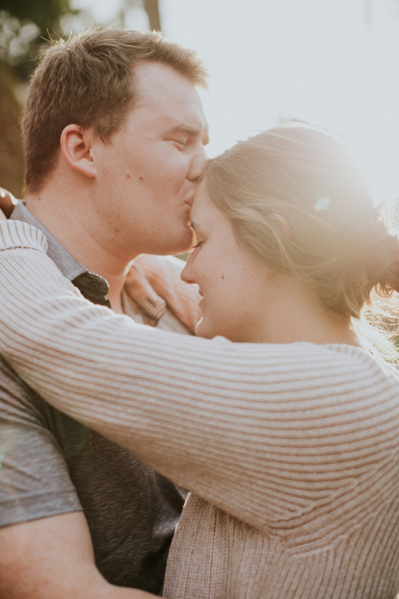 Couple Forehead Kiss Engagement Session Backlit by Sun