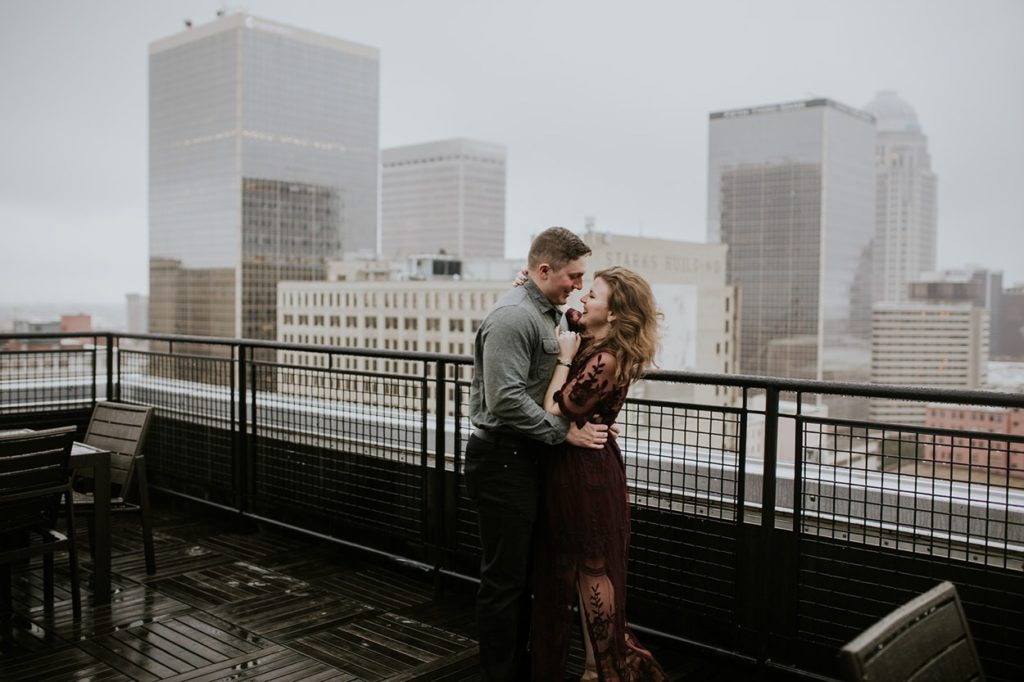 skyline downtown during louisville engagement session with young hipster couple hugging