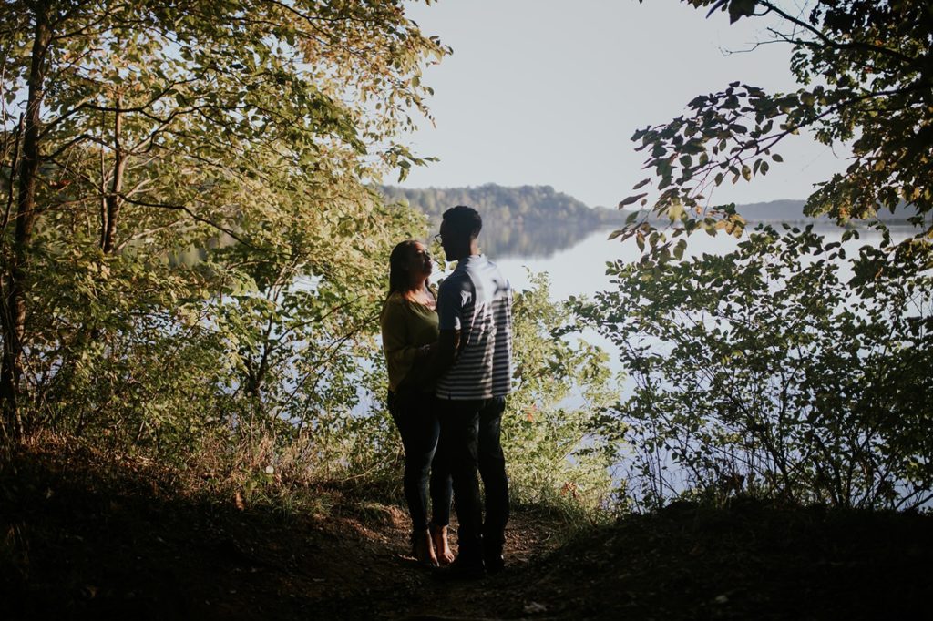 man and woman stand in front of eagle creek reservoir, one of the Best Indianapolis Engagement Photo Locations