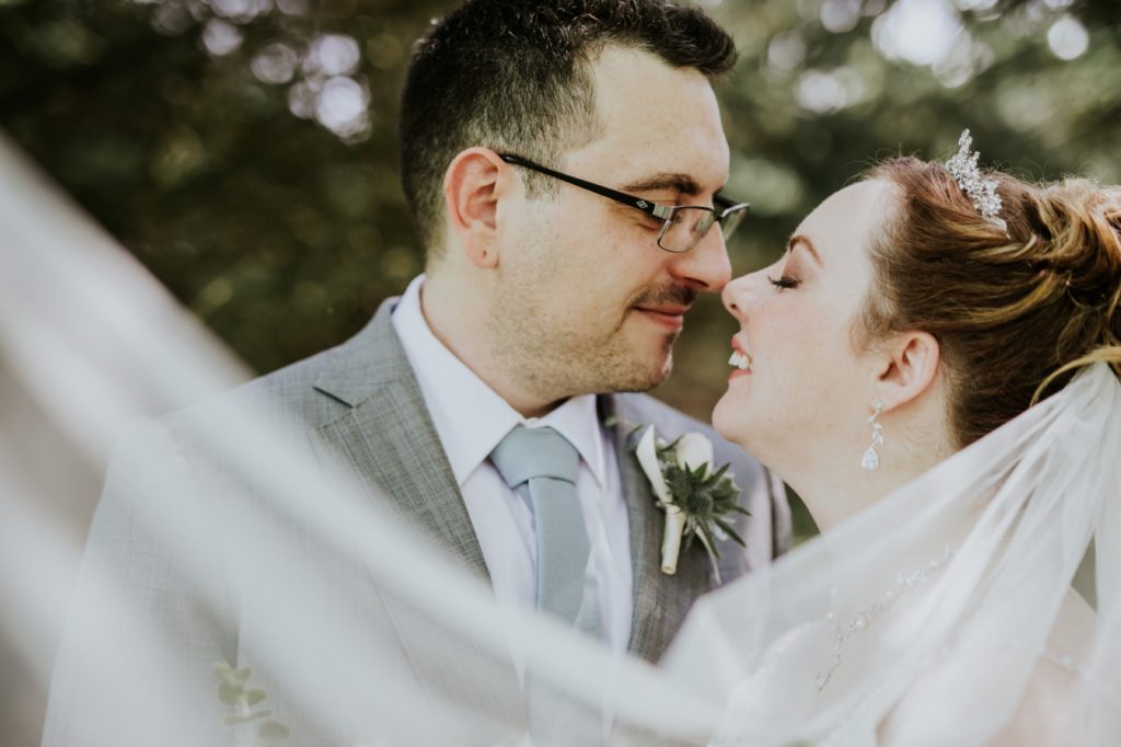 bride and groom kiss behind veil at norris estate wedding