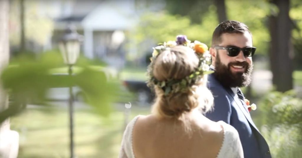 man in sunglasses sees woman with floral crown for first time on their wedding day