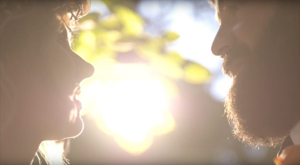 bride and groom prepare to kiss in front of setting sun during their benton house wedding film