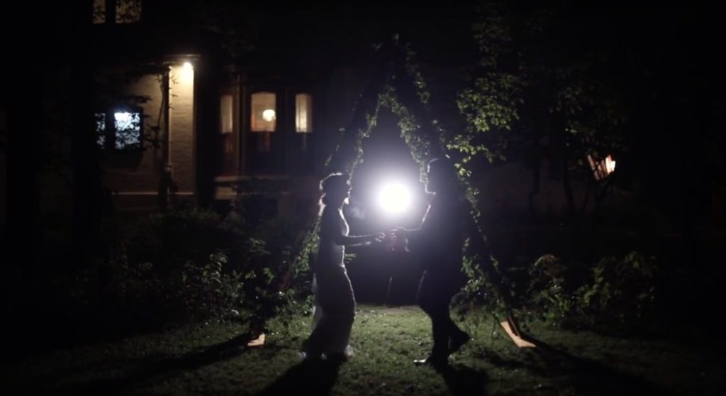 bride and groom dance at night in front of their floral triangle during their benton house wedding film