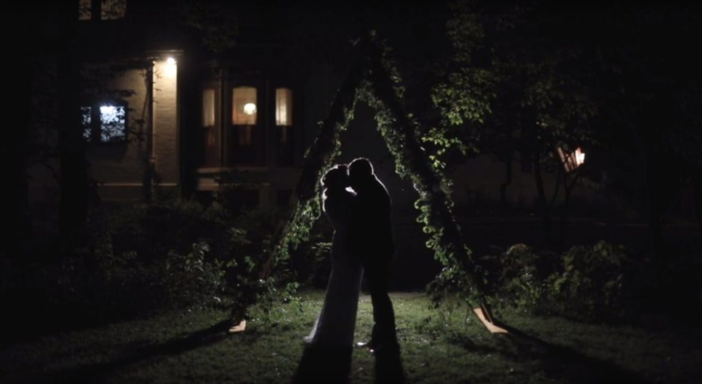 wide shot of bride and groom kissing at night during their benton house wedding film
