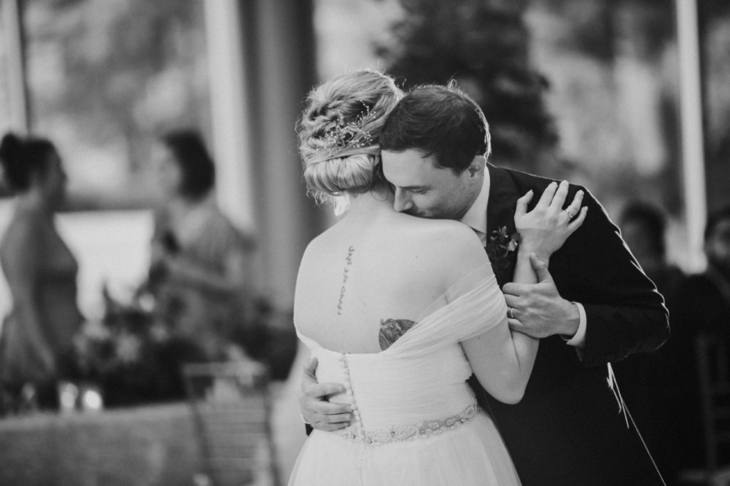 black and white photo of bride and groom dancing close during their first dance at IMA wedding in deer zink pavilion