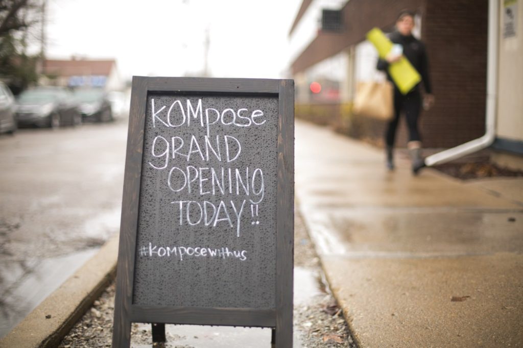 kompose yoga grand opening sign in the rain