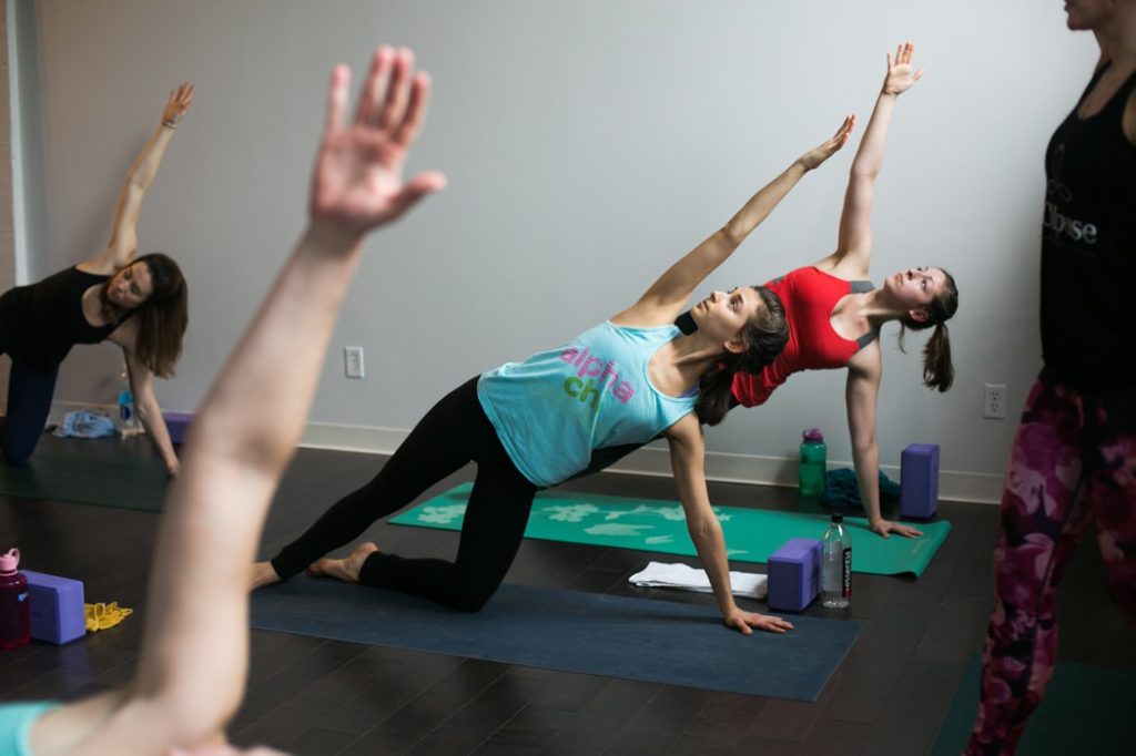 women holding themselves up on the sides with one arm while other arm is in air during an Indianapolis Yoga Photography shoot