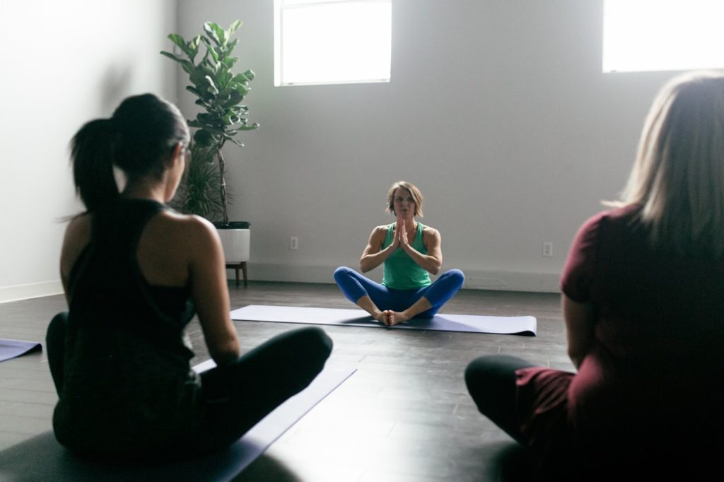 woman instructs yoga class during meditation during an Indianapolis Yoga Photography shoot