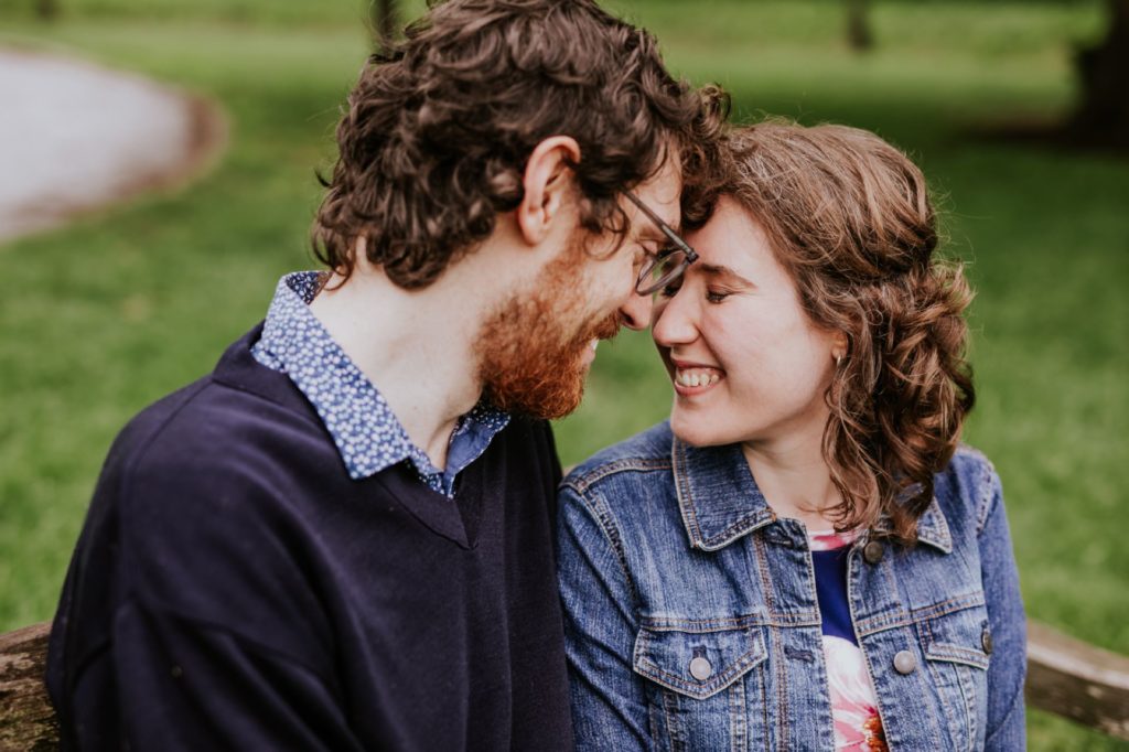 cute couple press foreheads together at their Holcomb Gardens engagement shoot