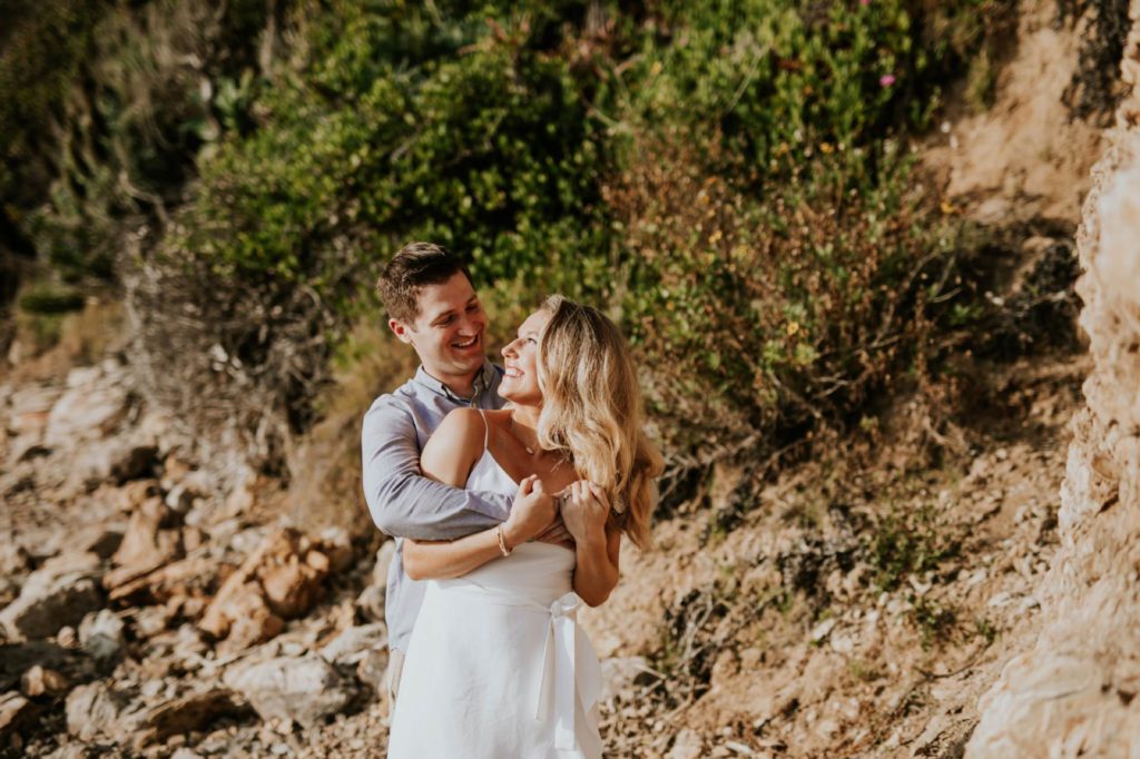 man and woman look at each other during laguna beach engagement shoot