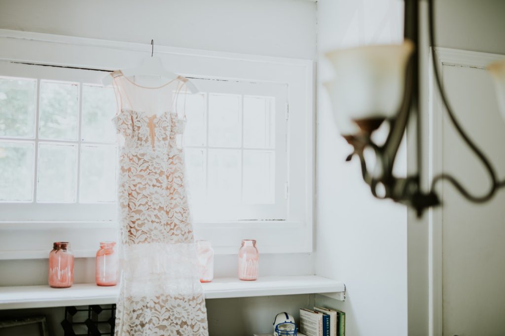 wedding dress hangs in window of airbnb in broad ripple in indianapolis