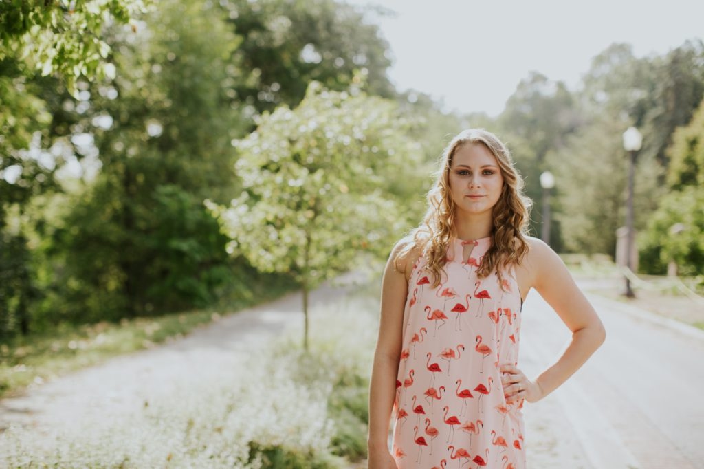 blonde girl in red dress stands with one hand on hip in this Muncie Indiana Senior Photography