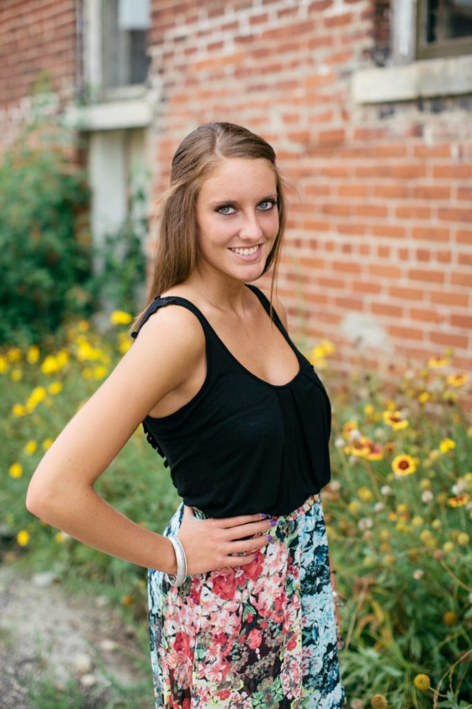 girl in black tank top smiling in front of flowers in Fishers portraits