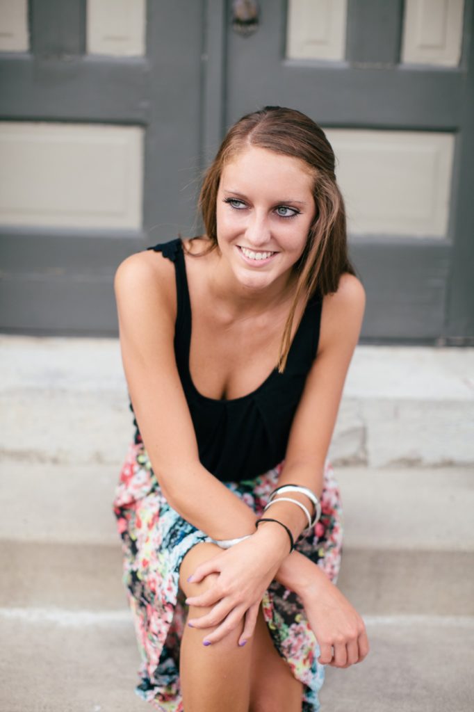 girl in black tank top sitting on steps of building in Noblesville Portaits
