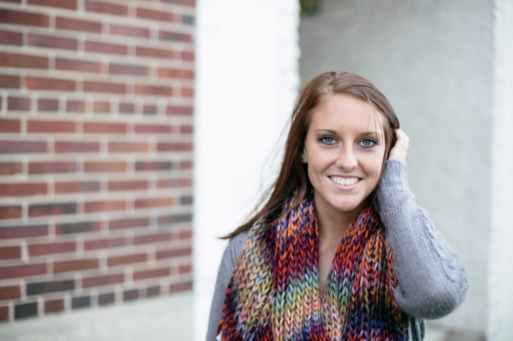 girl with scarf brushes hair out of face on windy day in muncie senior pictures