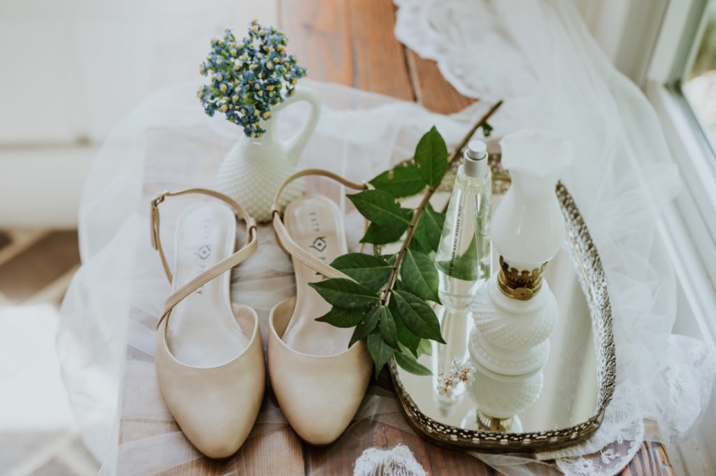 shoes flowers perfume and rings on wood floor for a wedding