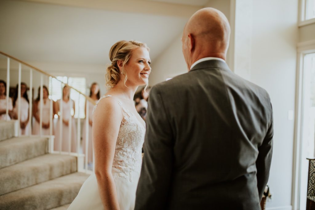 bride smiles and cries with father