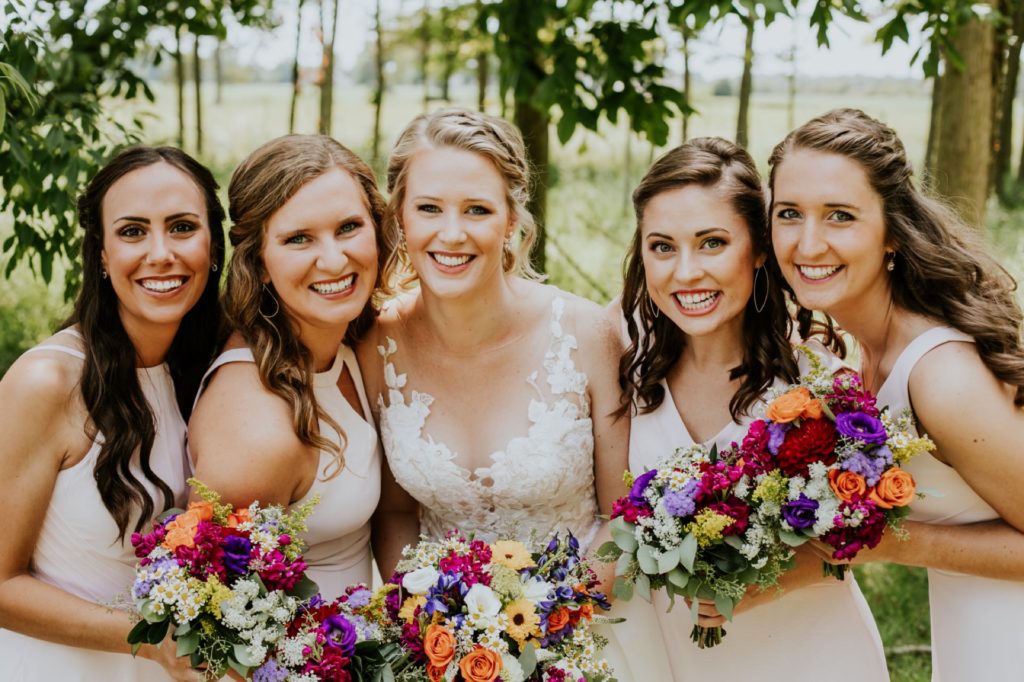 bride and bridesmaids with flowers outside for muncie wedding photography