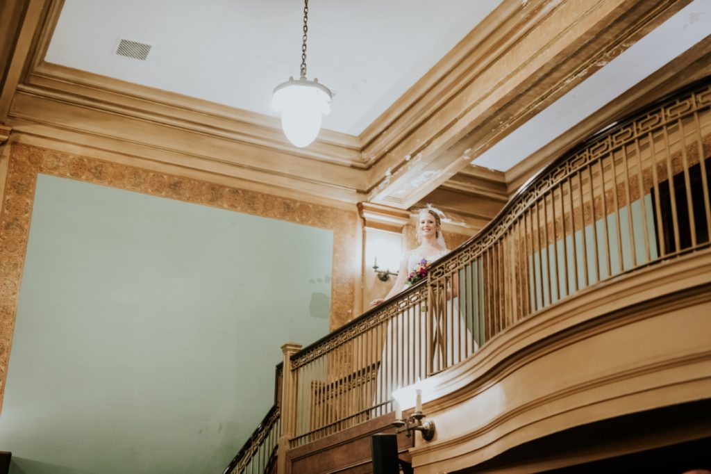bride standing on balcony for grand entrance to muncie wedding photography at cornerstone center for the arts