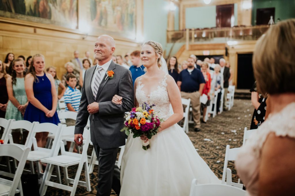 bride and father walk down aisle at cornerstone center for the arts for their muncie wedding photography