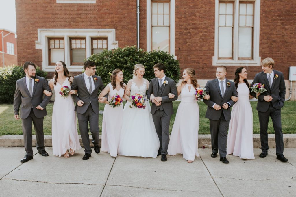 bridal party walks while linking arms for muncie wedding photography