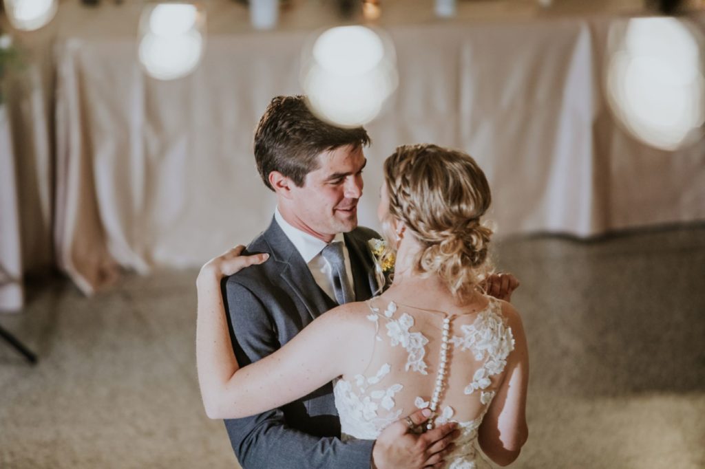 bride and groom dance under string lights at cornerstone center for the arts