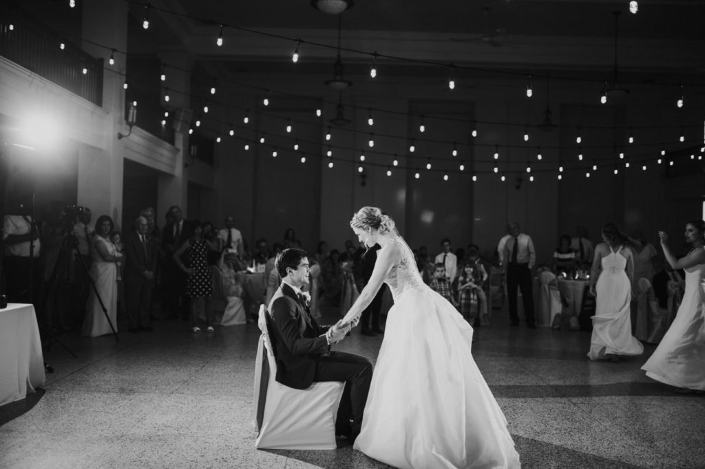 bride pins groom to a chair during their muncie wedding photography