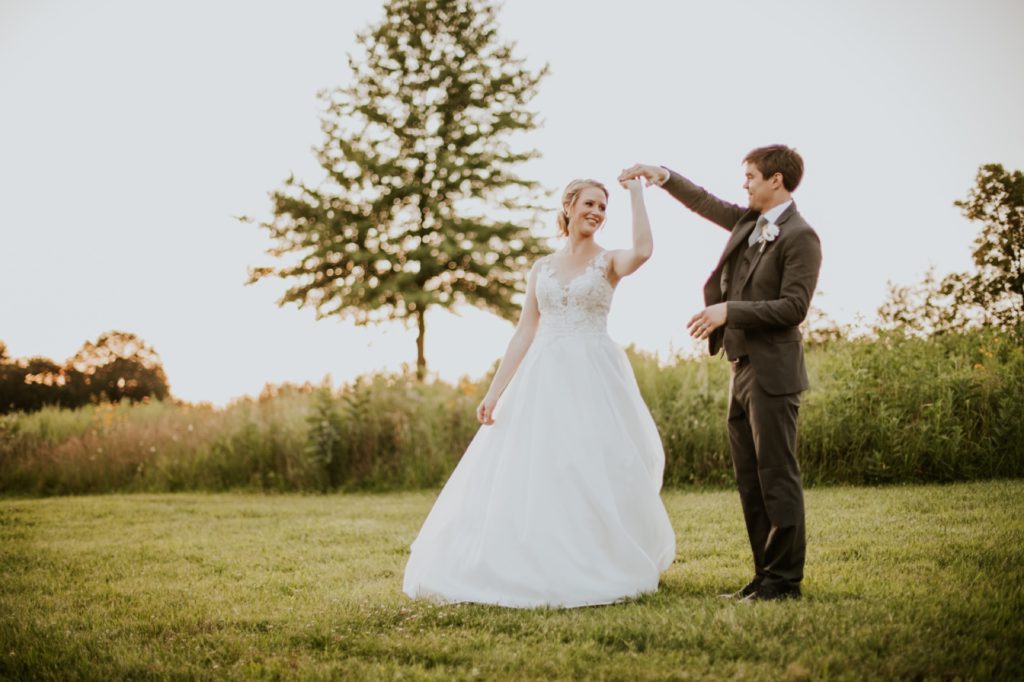 bride and groom dance at sunset in front of field with one lonely tree during their muncie wedding photography