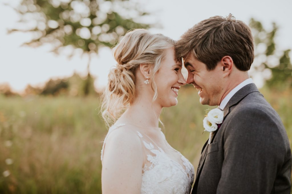 bride and groom laugh while touching foreheads together during their muncie wedding photography