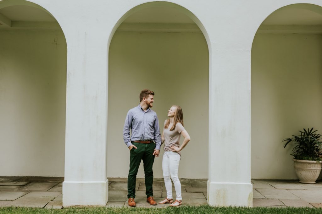 a man and a woman look at each other under an arch of the lilly house during these Newfields family photos