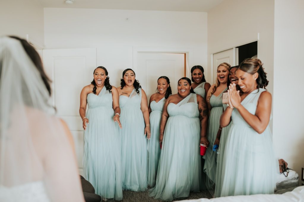 bridesmaids squeal with delight as they see the bride for the first time in alexander hotel