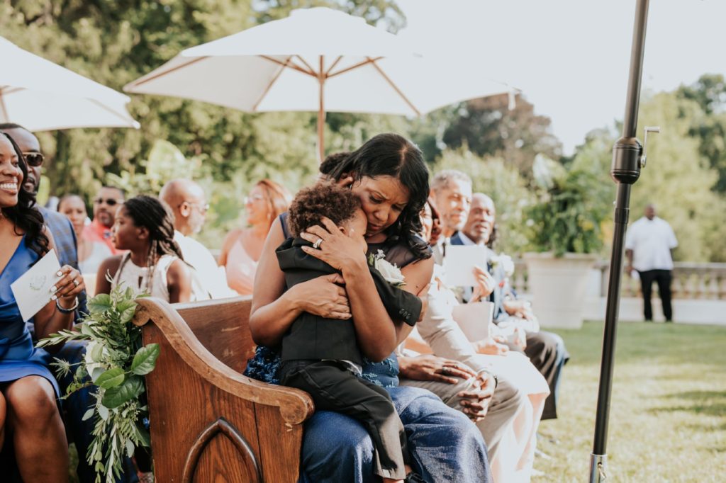mother of bride hugs ring bearer at a newfields wedding
