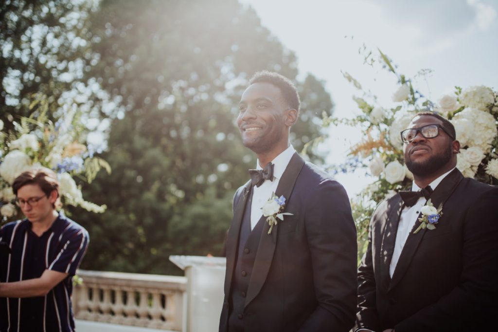 groom smiles as he sees bride for first time at newfields wedding ceremony