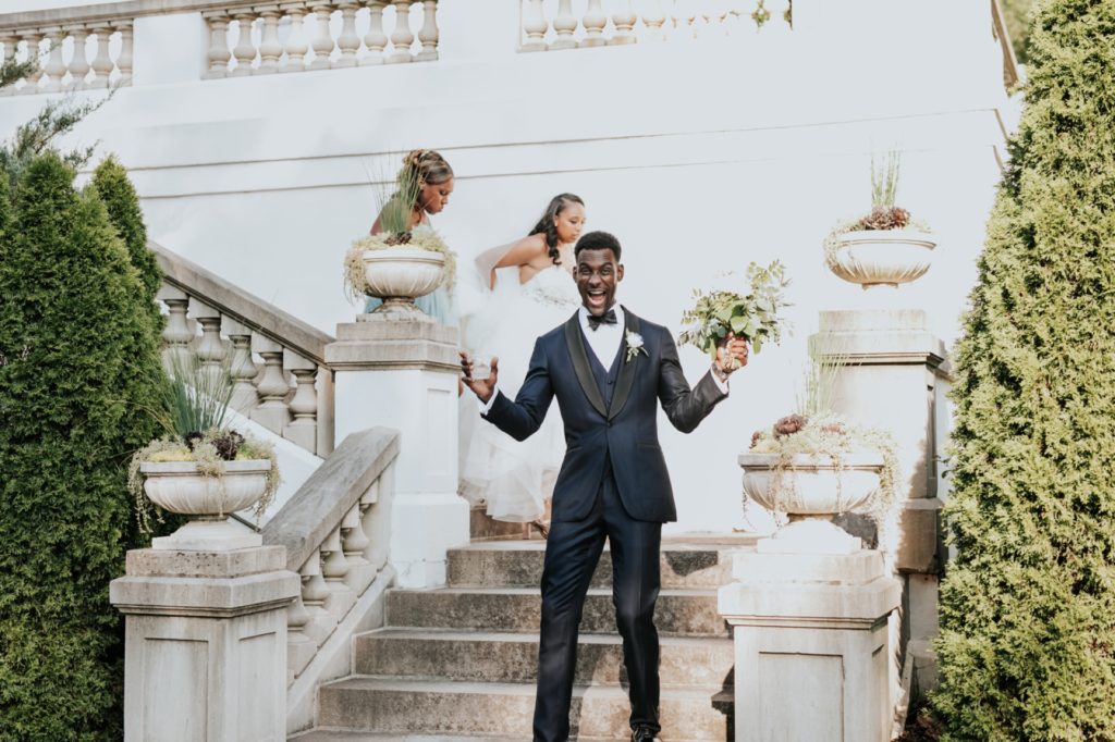 groom smiles on steps of lilly house at newfields wedding