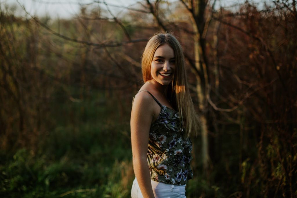 dark and moody photo of girl in the woods at sunset for Westfield Senior Portraits