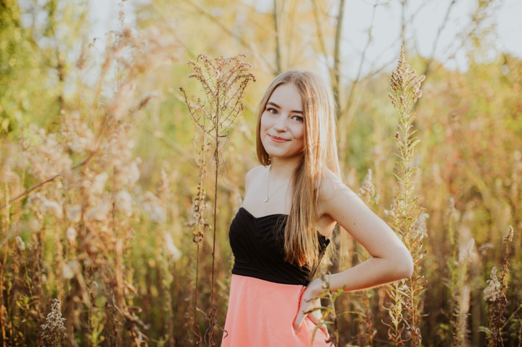 girl in pink dress in front of tall grass for Carmel Portraits