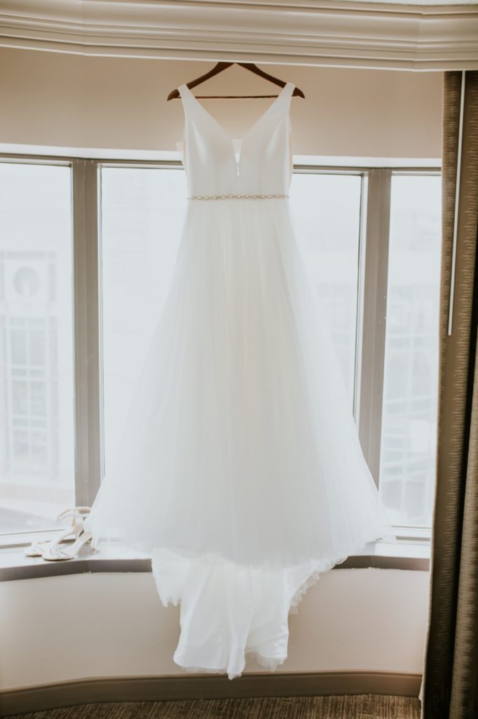 wedding dress hanging in a window