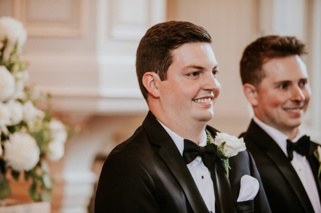 groom smiles as he sees bride for the first time at meridian street united methodist church