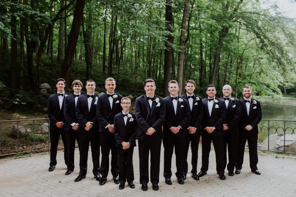 groom and groomsmen in a flying v formation at holcomb gardens at butler university before a Tinker House Wedding