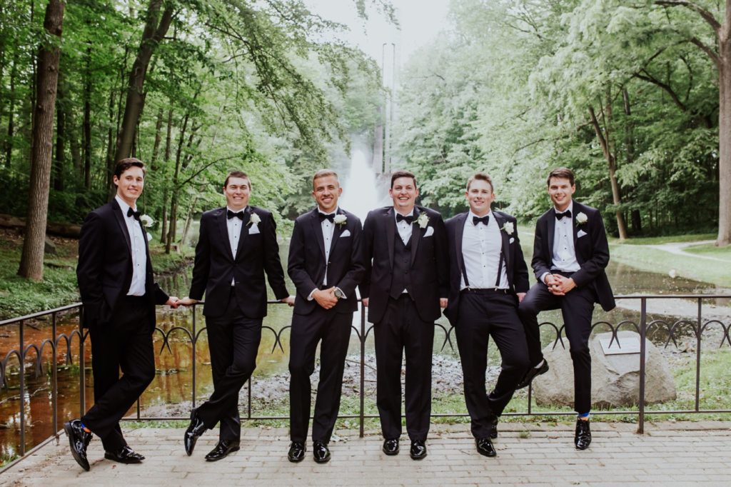 groom and groomsmen nonchalantly hanging out at holcomb gardens at butler university before a Tinker House Wedding
