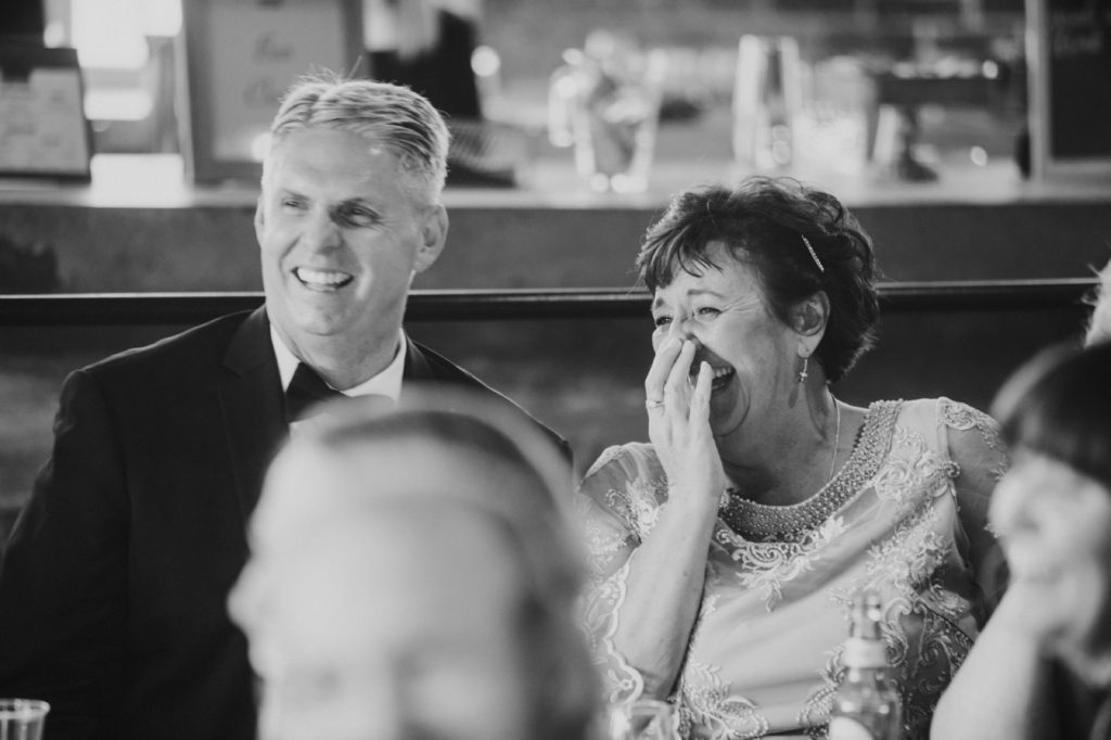 parents of groom laugh at speeches in black and white photo at a Tinker House Wedding