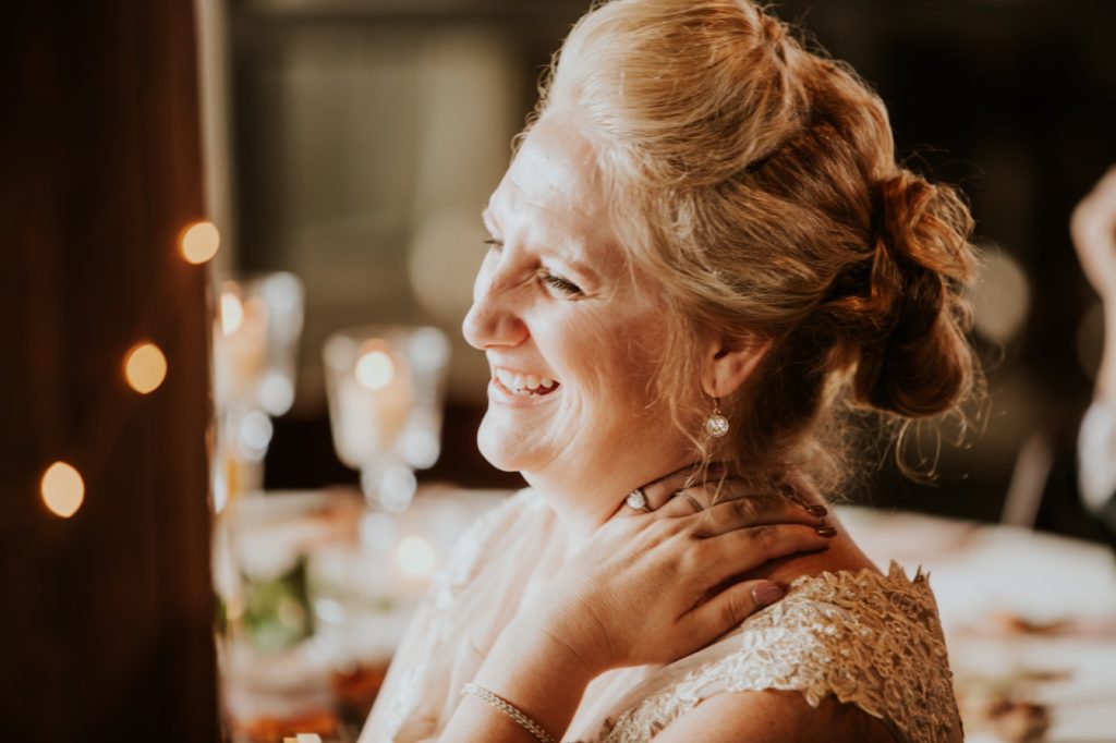 mother of bride laughs at speeches in golden light at a Tinker House Wedding