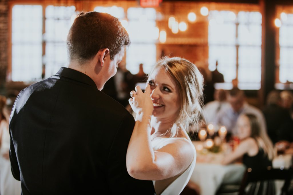 bride cries with happiness and wipes tear away from eyes during first dance at her Tinker House Wedding