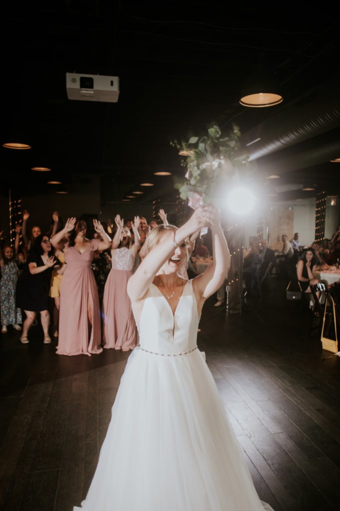 bride throws bouquet during her Tinker House Wedding