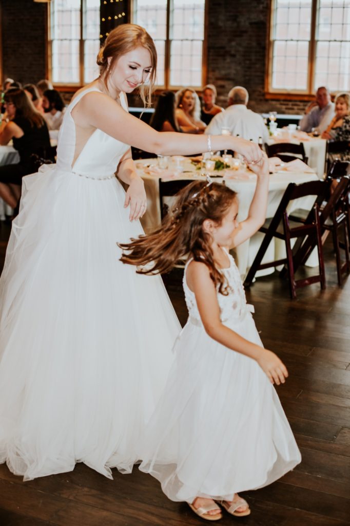 the bride dances with the flower girl during her Tinker House Wedding