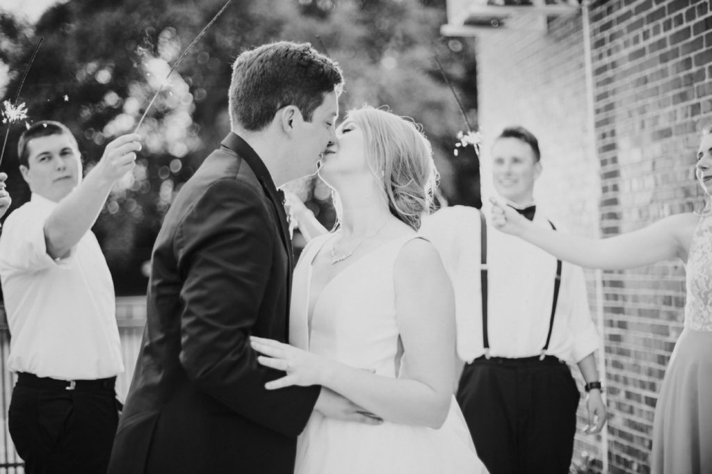 black and white photo of a bride and groom kissing in the middle of sparklers during a Tinker House Wedding