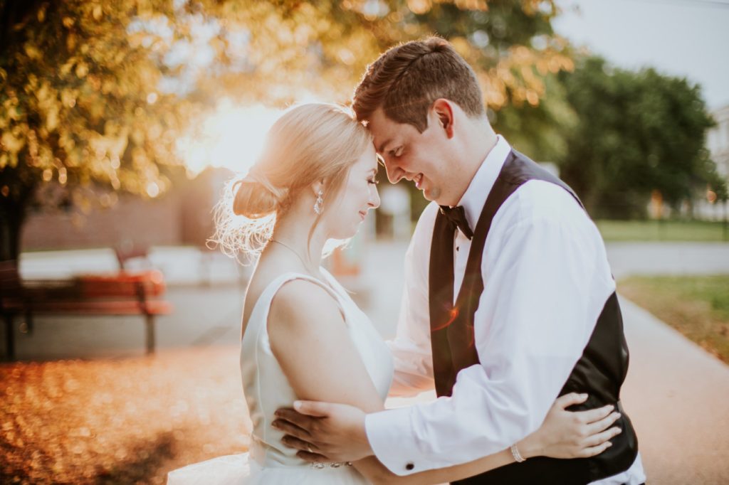 bride and groom illuminated by sunset touch foreheads at the end of their Tinker House Wedding