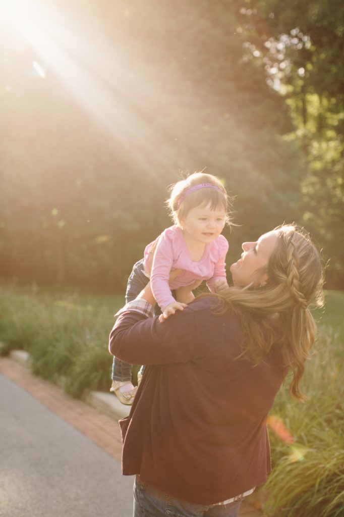 mom holds daughter and orange flare streaks across picture at minnetrista