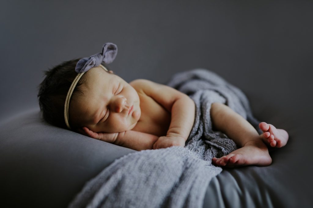cute baby sleeps on gray background Noblesville Newborn Photography