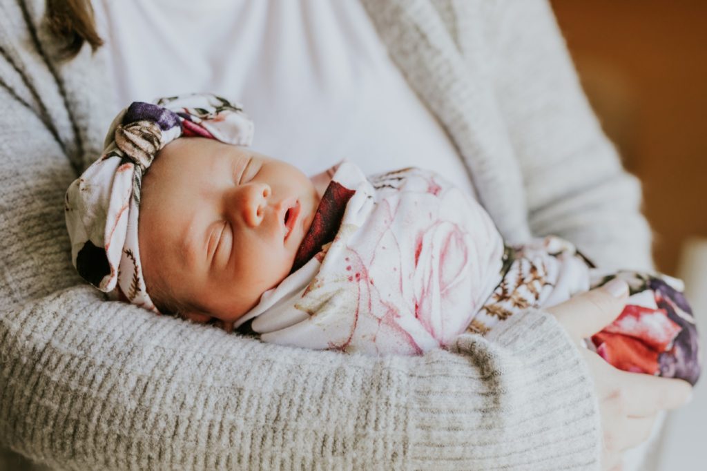 little baby with floral headband in mother's arms for fisher family portraits